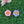 Load image into Gallery viewer, two flower-shaped objects, one pink and one purple, resting on a green surface.