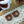 Load image into Gallery viewer, two chocolate bear-shaped cookies placed on a lace doily, with a pine cone and a mushroom in the background.