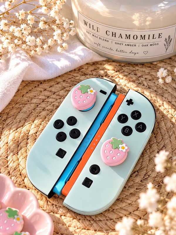 Strawberry thumb grips on Nintendo Switch 2 Joy-Con controllers - pink silicone joystick caps (set of 2)