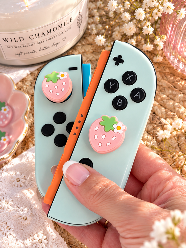 Holding Switch 2 Joy-Con with strawberry thumb grips - cute floral silicone joystick caps