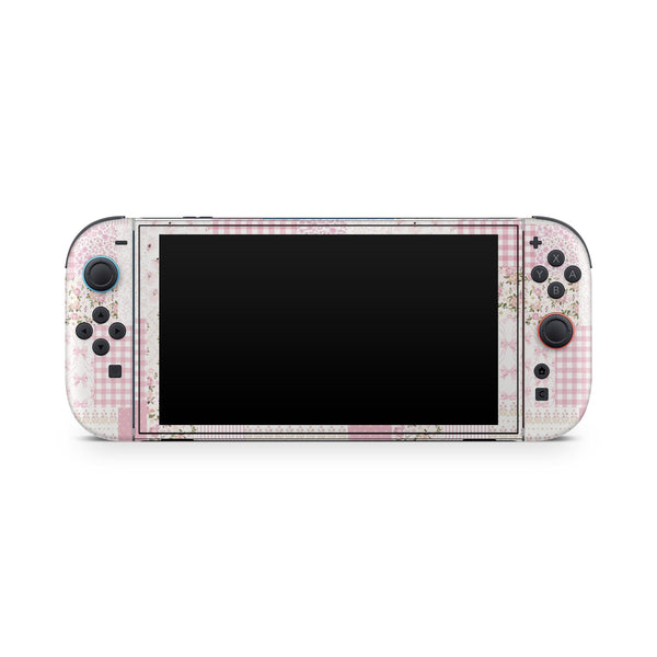 A Nintendo Switch console with a pink and white checkered pattern on its body and a black screen.