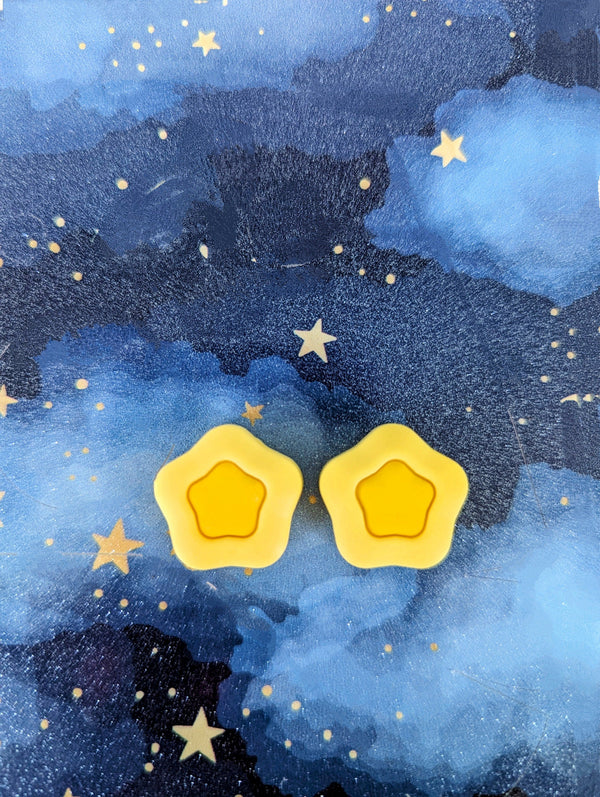 two yellow star-shaped objects against a starry night sky background.